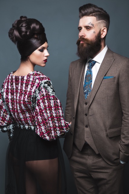 Couple, man and woman in evening dresses posing for studio photo shoot